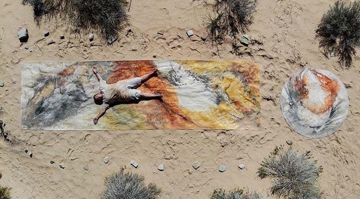 Ulrike Arnold mit ihrem Gemälde in der Wüste